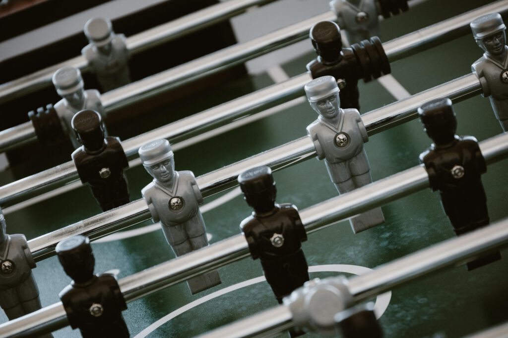 Foosball tournament Silver and black playing pieces in a foosball table.